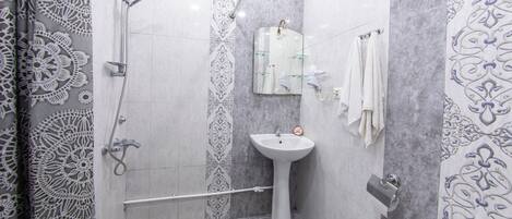 A bathroom with a shower, sink, and toilet.