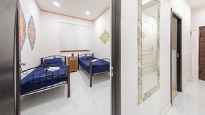 A bedroom with two single beds, a wooden nightstand, a mirror, and decorative wall art. - Armena Hostel (Yerevan)