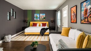 Une chambre à coucher moderne avec un grand lit, un canapé et des œuvres d’art accrochées aux murs.