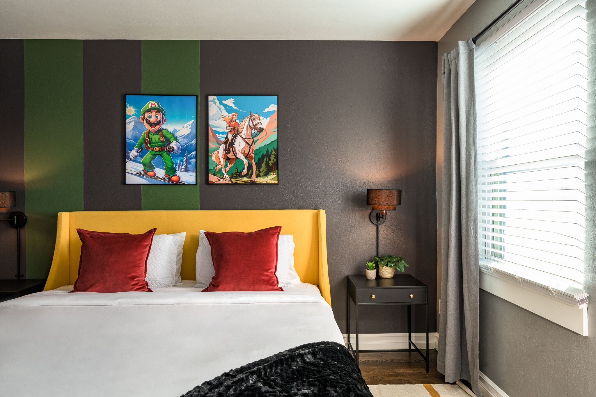 A bedroom with a yellow headboard, two red pillows, a white bedspread, and two framed pictures on the wall.
