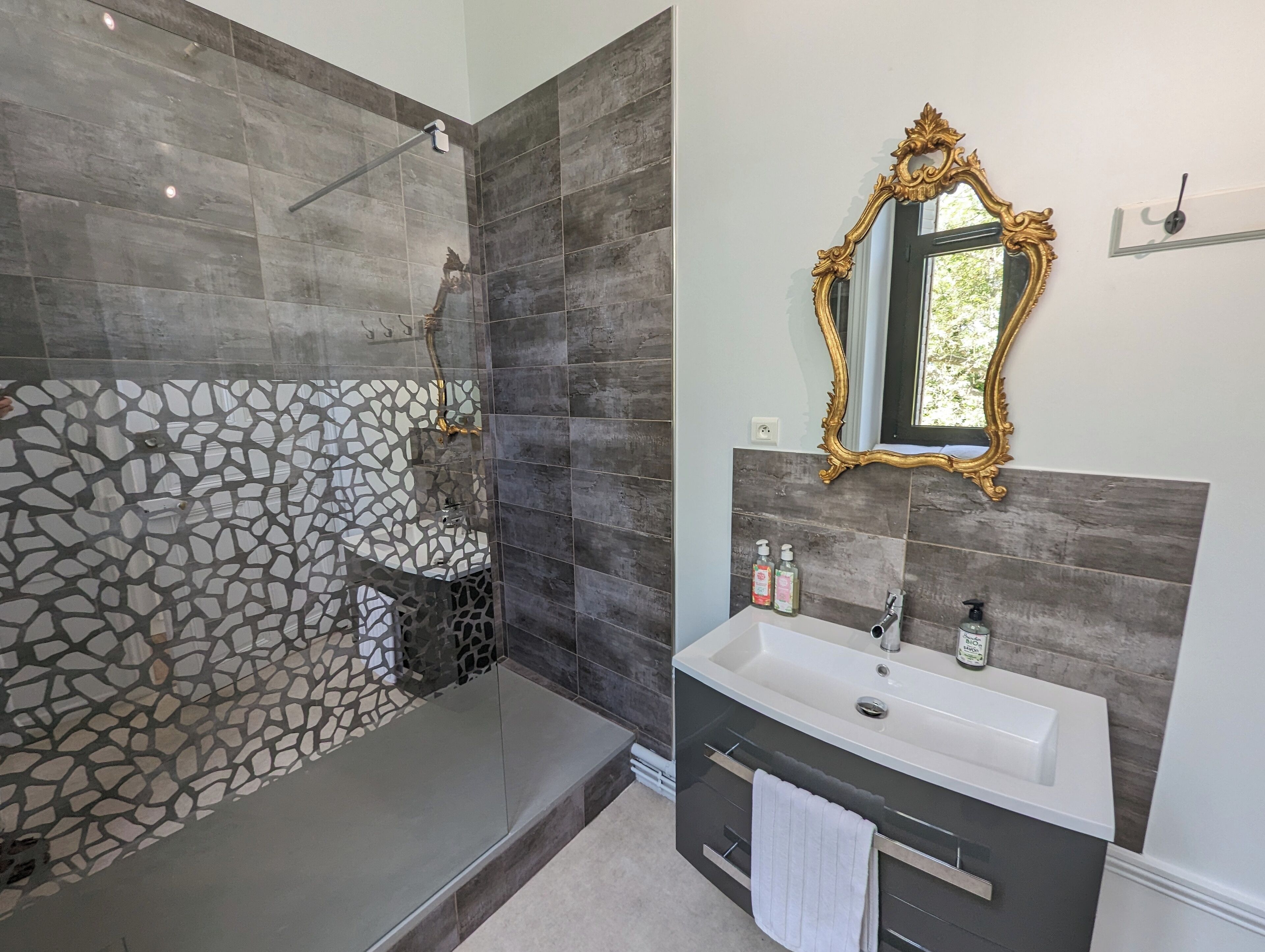 Baño con ducha, lavabo y espejo.