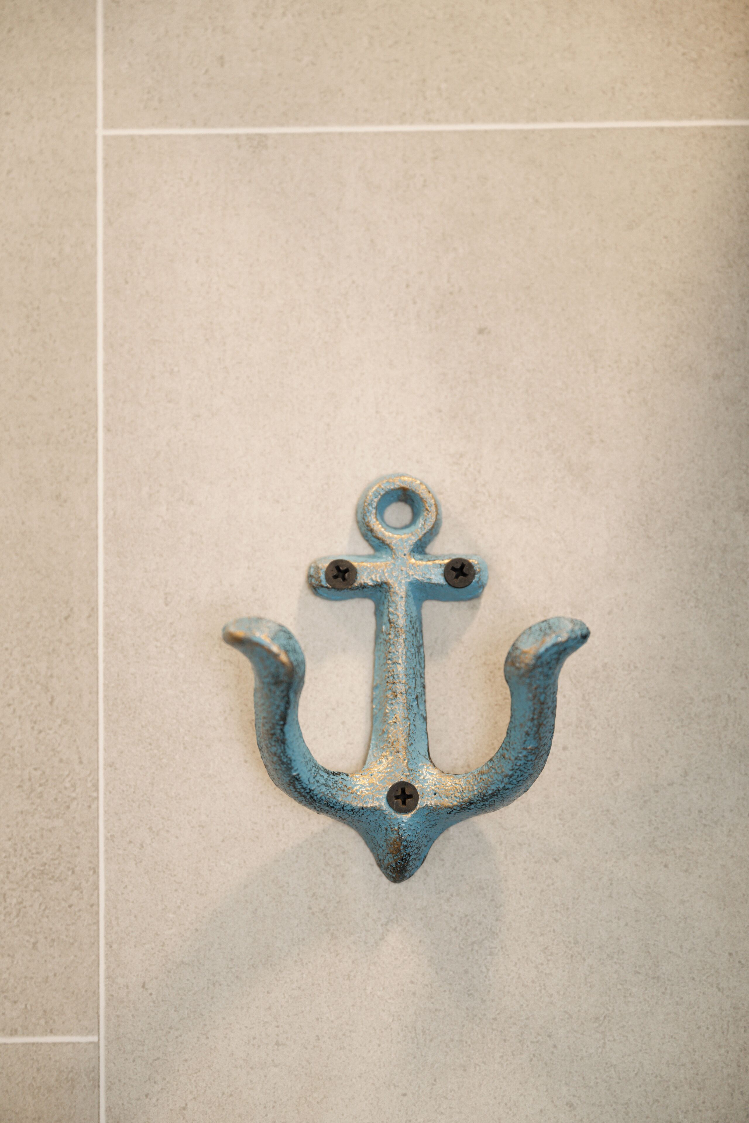 A blue anchor decoration on a tiled wall.
