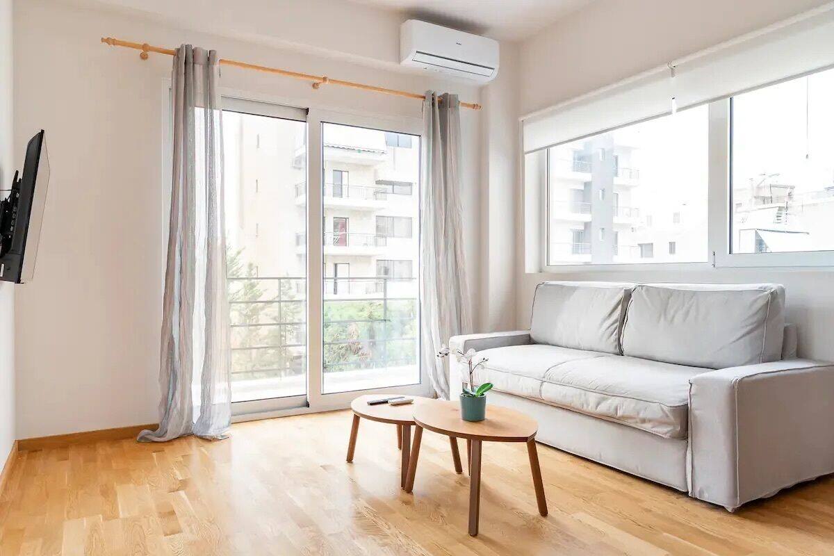 A modern living room with a sofa, a small table, and a large window.