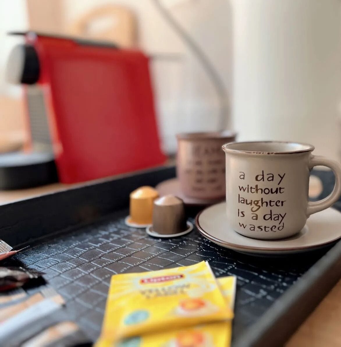 A kitchen counter with a coffee maker, a mug with a motivational quote, and some kitchen items.