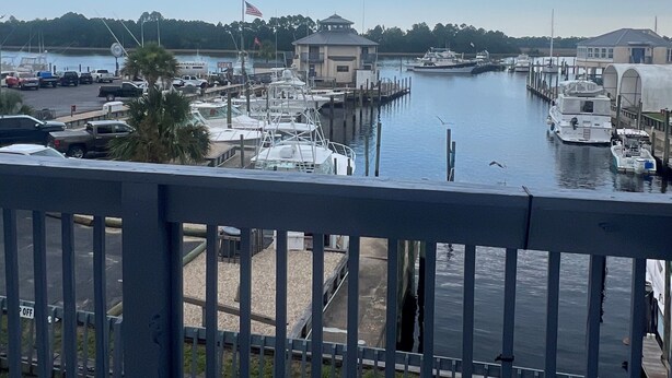 A marina with boats docked, a small building, and a clear sky. - The Moorings Hotel and Marina  (Carrabelle)