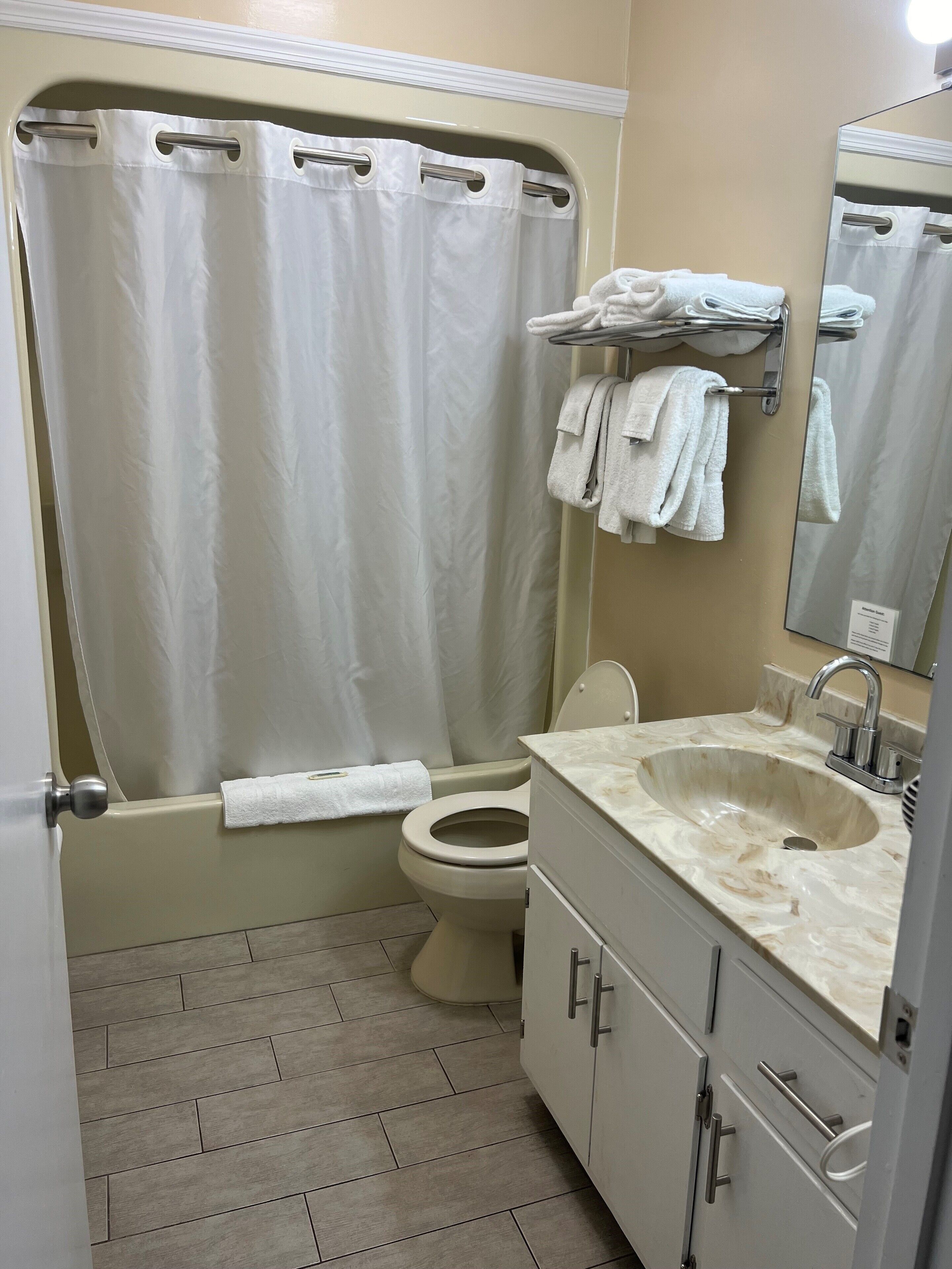 A bathroom with a bathtub, toilet, sink, and a towel rack.
