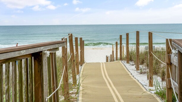 Una passerella in legno che conduce a una spiaggia, con una vista libera sull'oceano.