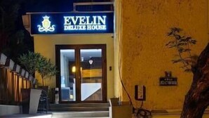 Un edificio con un letrero que dice 'Evelin Deluxe House' de noche.