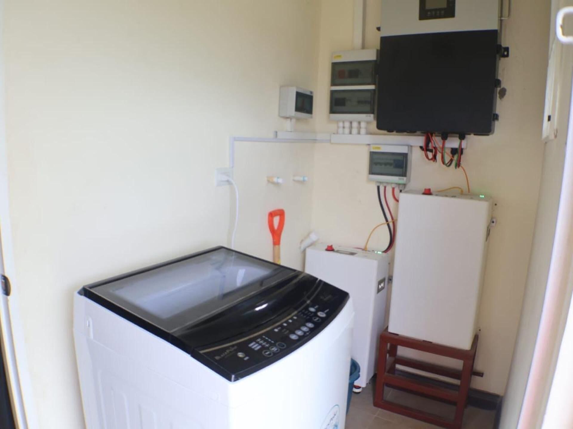 A compact laundry room with a washing machine, a dryer, and a small cabinet with a television.