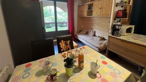 A compact room with a dining table, chairs, a sofa, a bed, and a kitchenette. - 250m from ski slopes, terrace, tv, 24m², Serre Chevalier (La Salle-les-Alpes)