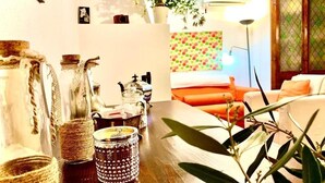 Een gezellige woonkamer met een houten tafel, decoratieve potjes en een plant.