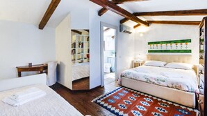 Een slaapkamer met een bed, nachtkastje, een boekenkast en een kamerkleed met dessin.