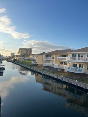 A waterfront property with a canal, a wooden dock, and buildings with balconies.