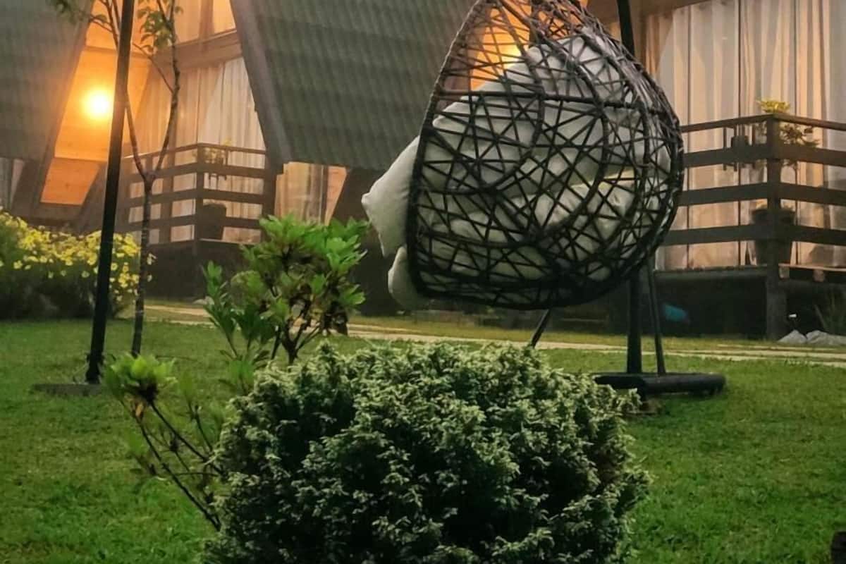 Un edificio moderno con techos triangulares y una silla colgante al frente.