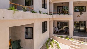 Relax in a serene outdoor space with comfortable seating and lush greenery.
