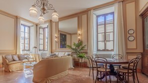 A spacious living room with a sofa, coffee table, and dining table with chairs. - Miranda's Home (Varenna)