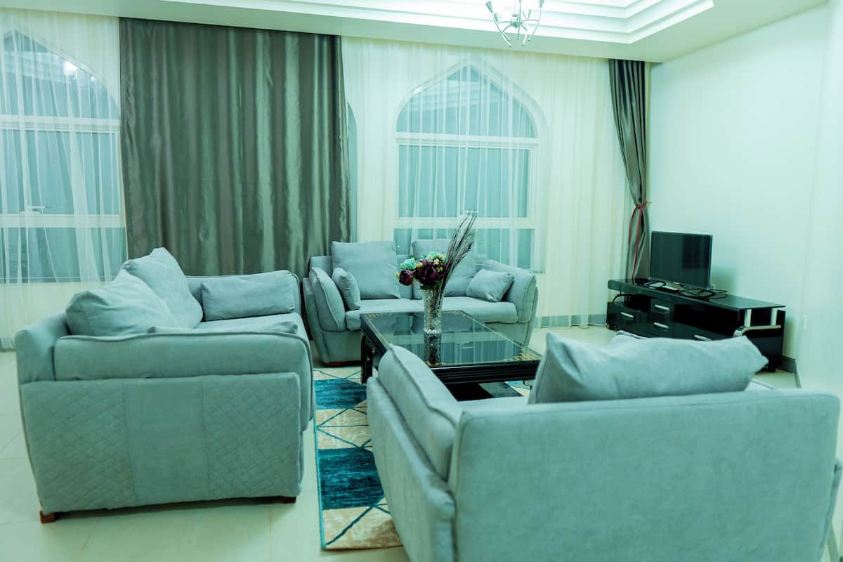 A modern living room with a sofa set, a coffee table, and a TV stand.