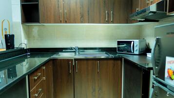 A kitchen with wooden cabinets, a microwave, and a refrigerator.