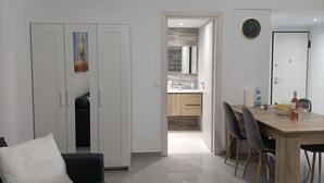 A modern living room with a sofa and a dining area with a table and chairs. - City Aurora (Athens)
