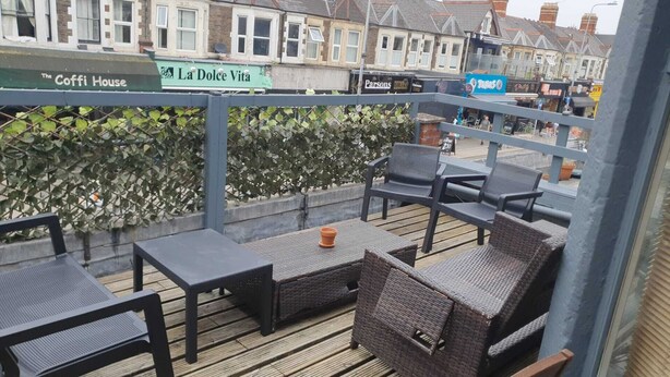 Un espace extérieur aménagé avec des meubles en osier et une terrasse en bois.