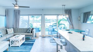 Un salon moderne avec un canapé, une table basse et un coin repas.