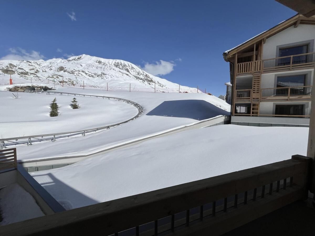 A snow-covered ski slope with a building on the right.