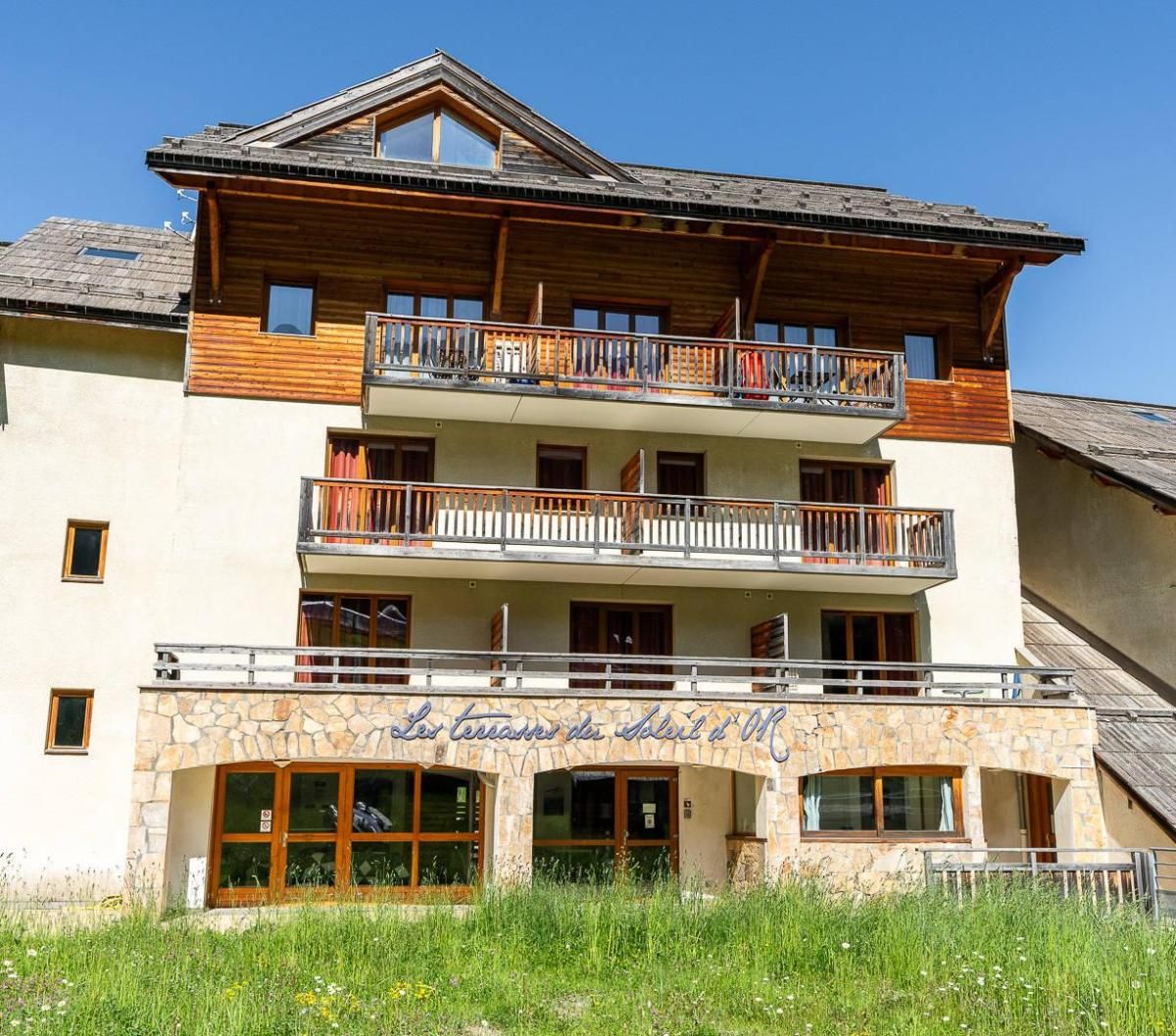 Un immeuble à plusieurs étages, doté de balcons, d’une façade en pierre et d’une enseigne indiquant qu’il s’agit d’un hôtel.