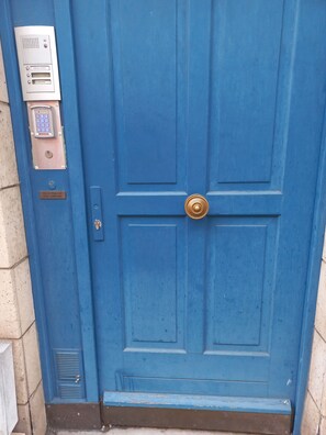 A blue door with a keypad lock, a brass door knocker, and a small sign above the lock. - Appartement au Coeur de Bayeux (Bayeux)
