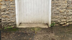 A white wooden door with the inscription "VILLA PAISIBILITE" and a small mailbox above it.