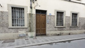 A building with a stone facade, a wooden door, and barred windows. - Torrigiani View by Mmega (Florence)