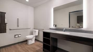 Habitación, 1 cama Queen size (Hearing Impaired Roll in shower) | Baño | Amenidades de baño gratuitas, secadora de cabello, toallas, jabón