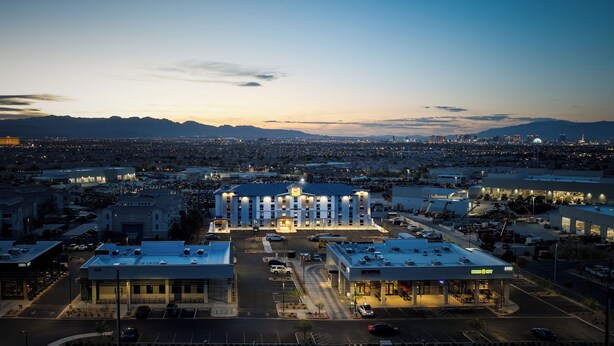 A hotel with a central courtyard, multiple floors, and a parking lot.