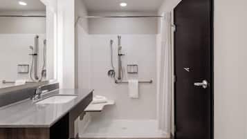 A modern bathroom with a shower, a sink, and a toilet.