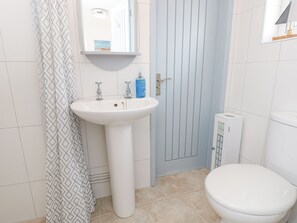 A bathroom with a white sink, a toilet, and a shower curtain.