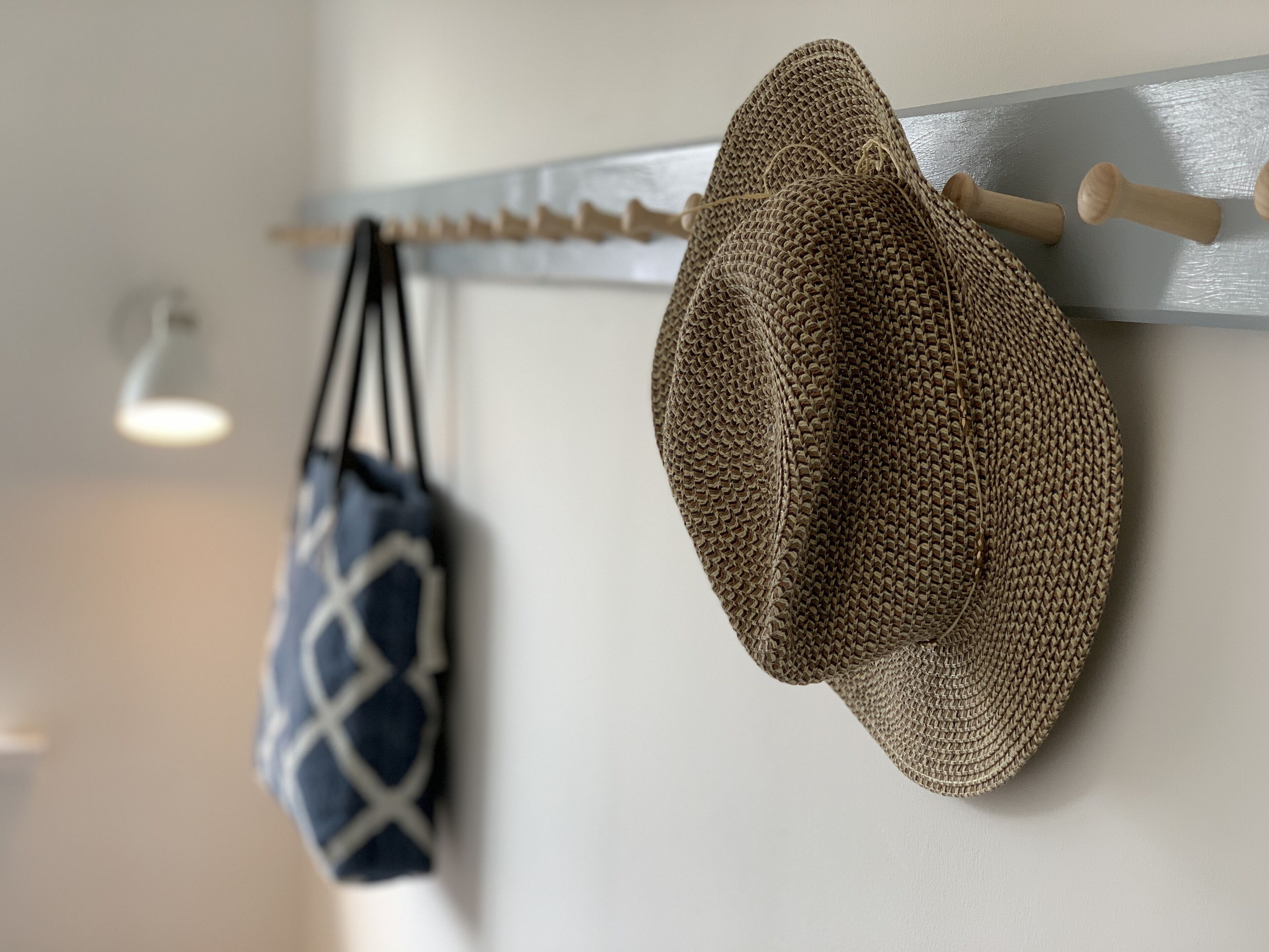 Un cappello e una borsa appesi a una mensola a muro.