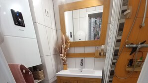 A compact bathroom with a toilet, sink, and shower. - Studio Trés Cocooning Pour Couple Aimant la Tranquillité, Avec Enfants (Gruissan)