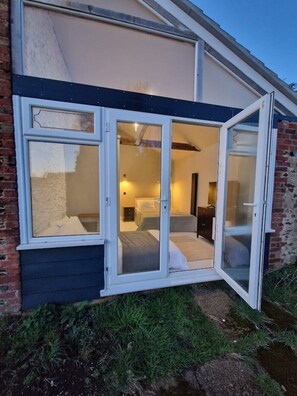 A room with a bed, a nightstand, and a lamp. - Garden Barn Studio, sleeps 3  (Heath and Reach)