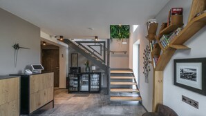 Et moderne interiør med trappe, receptionsdisk og siddeområde.