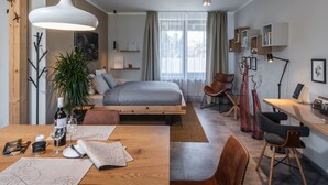 Et moderne soveværelse med seng, sengebord og et skrivebord med stol.