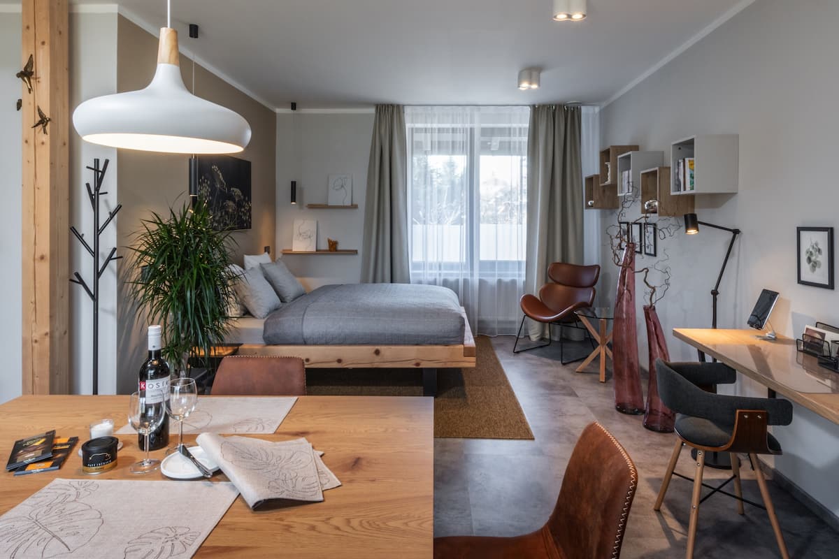 Ein modernes Schlafzimmer mit einem Bett, einem Nachttisch und einem Schreibtisch mit Stuhl.