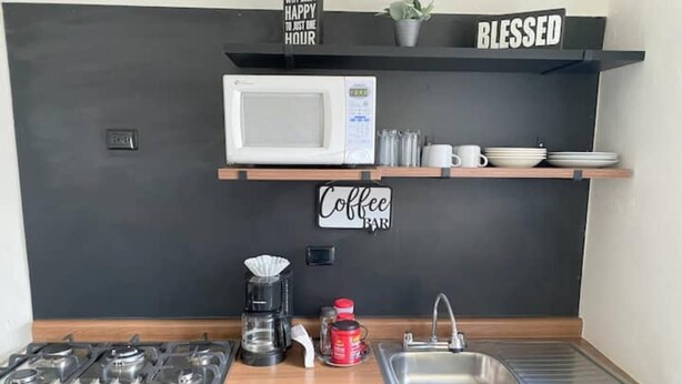 A compact kitchen with a microwave, coffee maker, and sink. - Departamento Cerca de Mall y D1.facturamos! (Chihuahua)