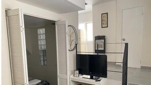 A bedroom with a bed, a TV, a bookshelf, and a window. - Departamento Cerca de Mall y D1.facturamos! (Chihuahua)