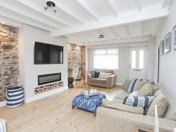 A living room with a fireplace, a sofa, a coffee table, and a television.