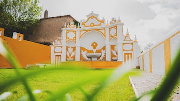 Stroll through the serene courtyard, surrounded by a low wall and a gravel path leading to a beautiful architectural feature.