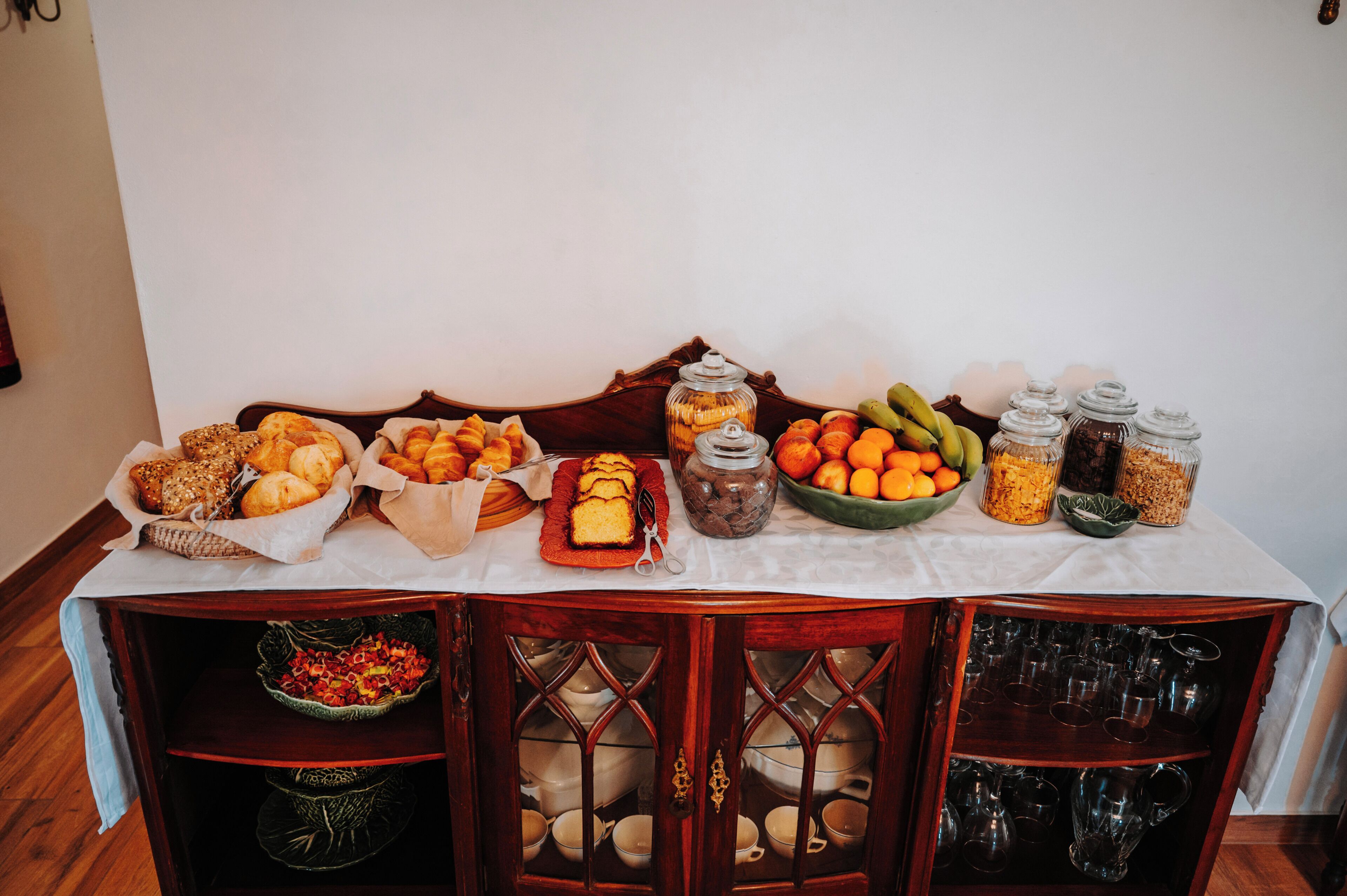 Una mesa de buffet con diversos alimentos y cristalería.
