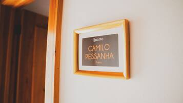 Uma placa com moldura na parede com o nome 'Camilo Pessanha' e a inscrição 'Poeta'.