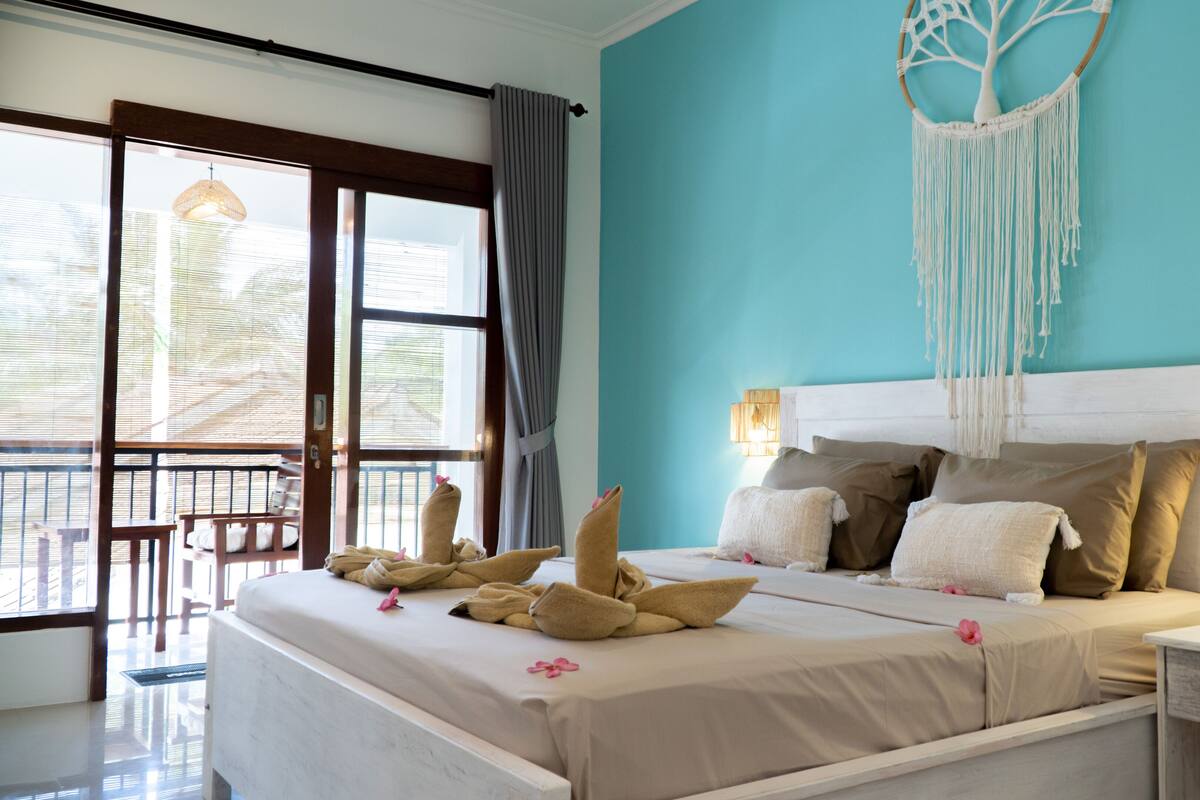 Un dormitorio con una cama grande, un balcón y un tapiz de macramé en la pared.