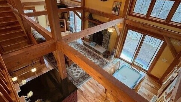 A multi-level wooden interior with a fireplace, large windows, and a staircase.