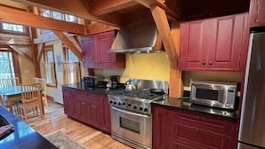 A spacious kitchen with wooden beams, a large island, and modern appliances.