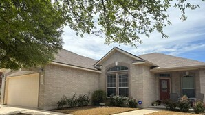 A single-story house with a garage, a front porch, and a small front yard. - Cozy 4-bedroom house in delightful San Antonio with AC, WiFi (San Antonio)
